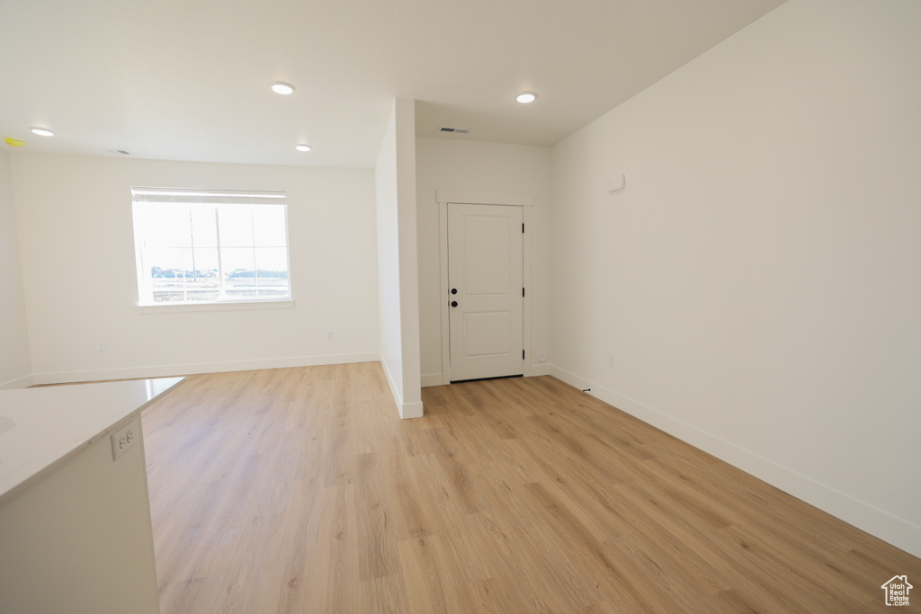 Empty room featuring light wood finished floors and recessed lighting