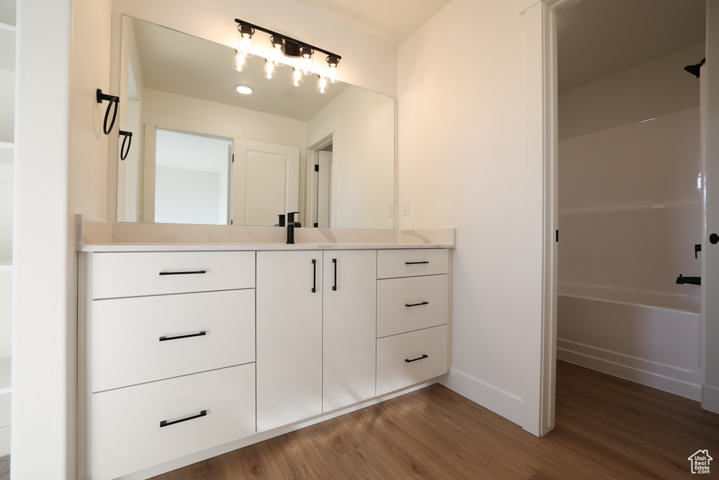Full bathroom featuring vanity, wood finished floors, and shower / bathtub combination