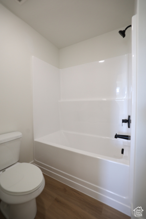Full bathroom with wood finished floors and shower / tub combination