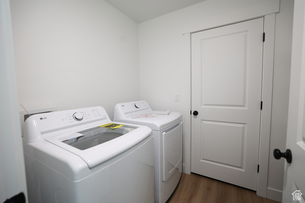 Washroom with washing machine and dryer and dark wood finished floors