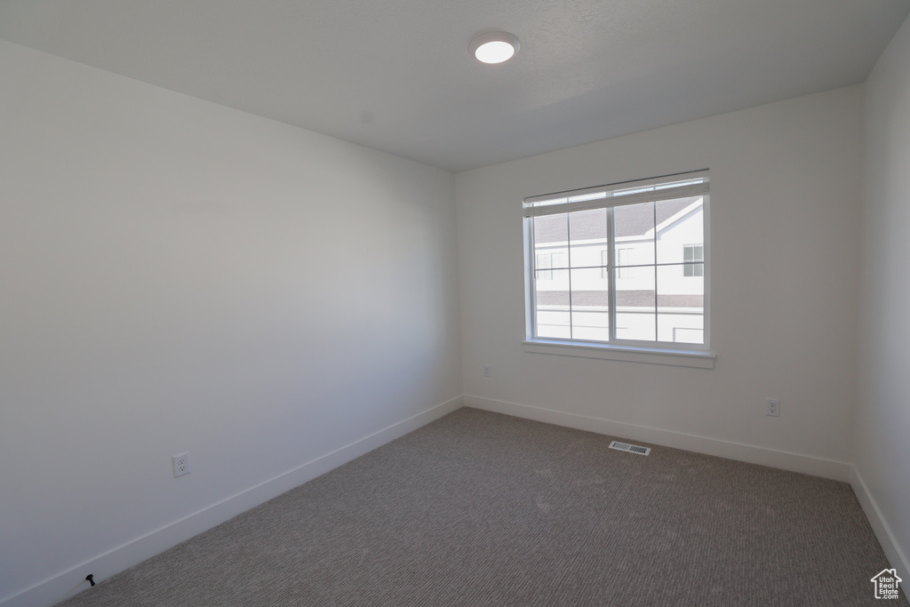Empty room featuring baseboards and carpet flooring