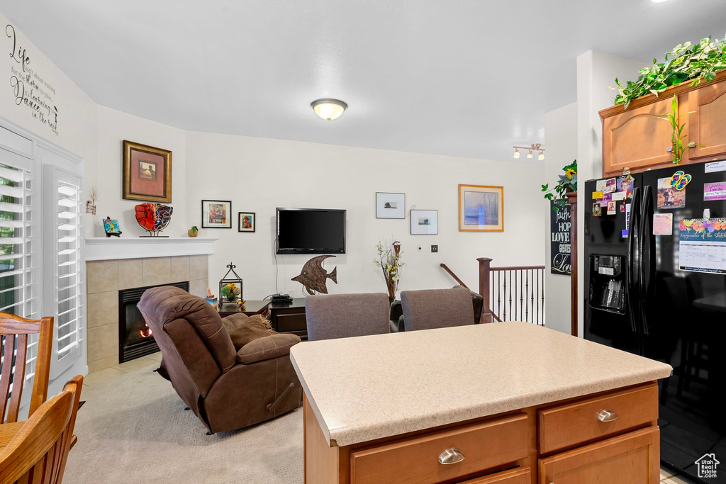 Living area featuring light colored carpet and a fireplace