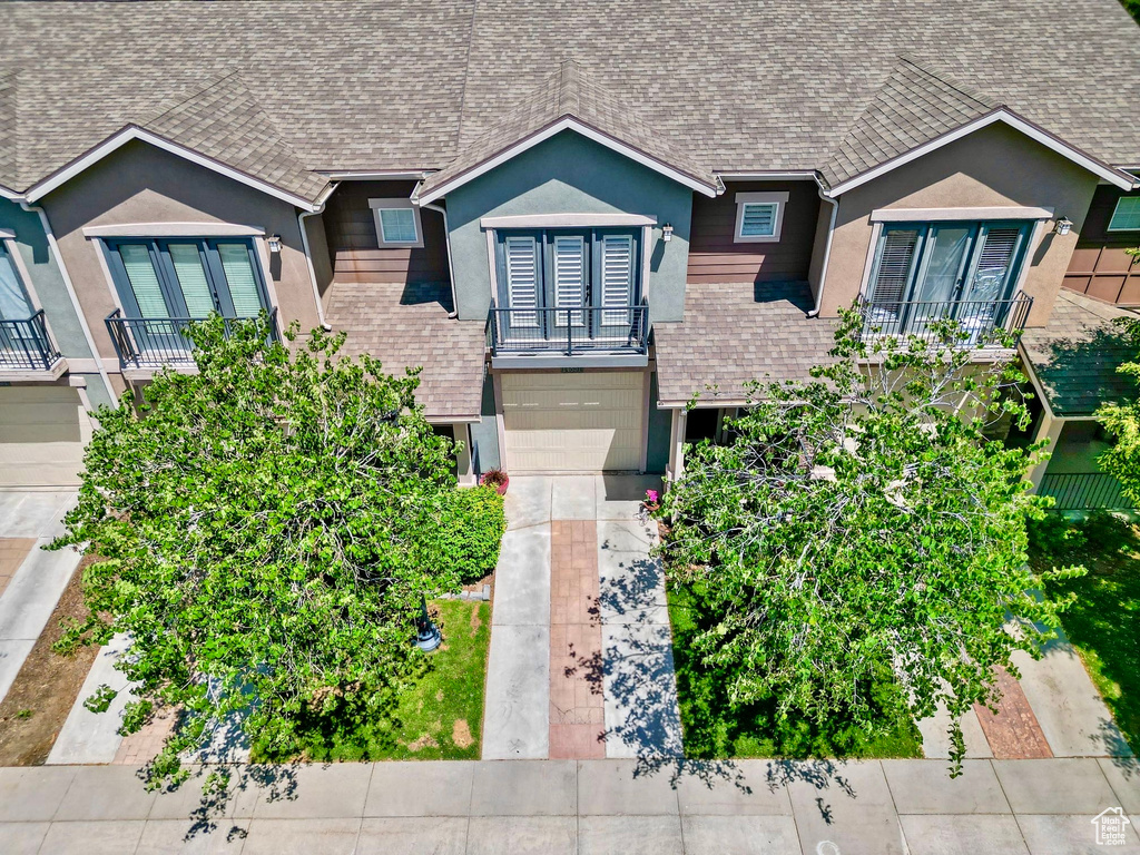Ranch-style house featuring french doors, stucco siding, roof with shingles, and a garage
