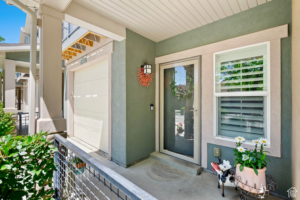 Doorway to property with stucco siding and a garage