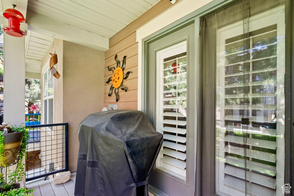 View of exterior entry featuring covered porch and stucco siding