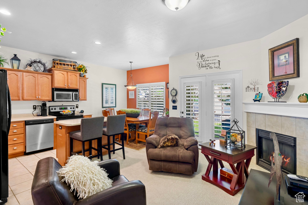 Living room with a fireplace, recessed lighting, and light tile patterned floors