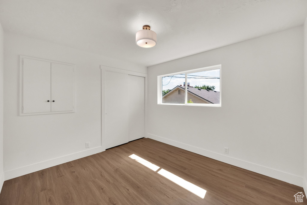 Unfurnished bedroom featuring wood finished floors and a closet