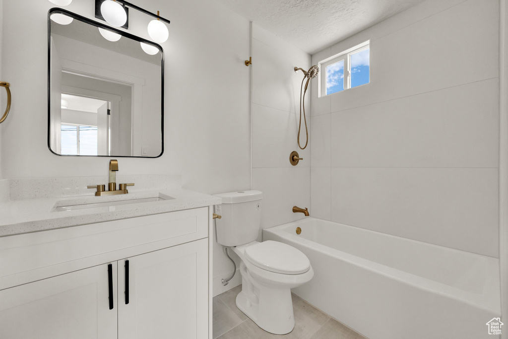 Full bathroom featuring vanity, bathing tub / shower combination, and a textured ceiling