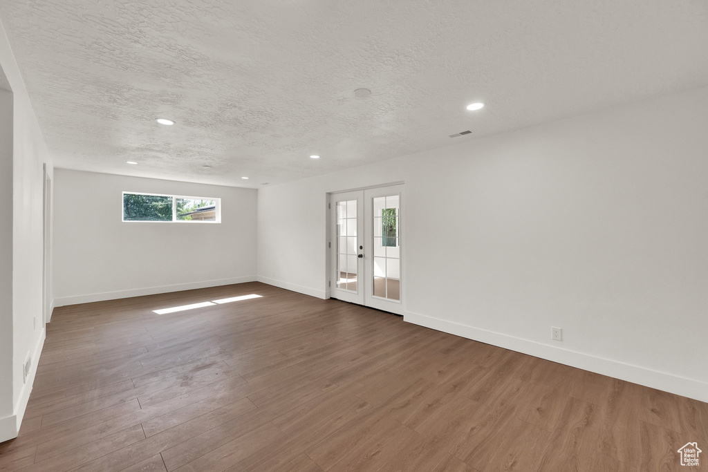 Spare room featuring a textured ceiling, dark wood finished floors, and recessed lighting