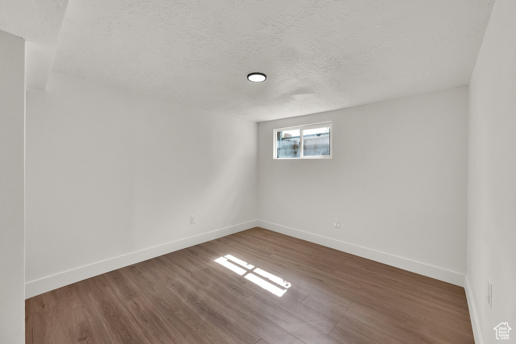 Spare room featuring a textured ceiling and wood finished floors