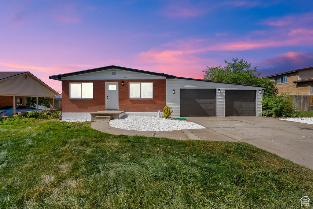 Ranch-style house with concrete driveway, a front yard, an attached garage, and brick siding