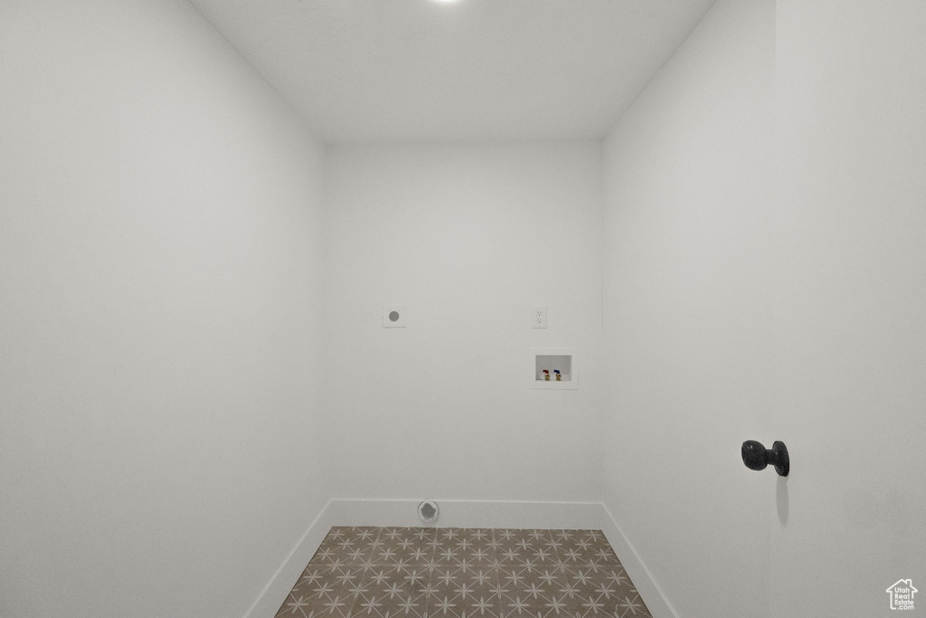 Laundry area with electric dryer hookup, hookup for a washing machine, and dark flooring
