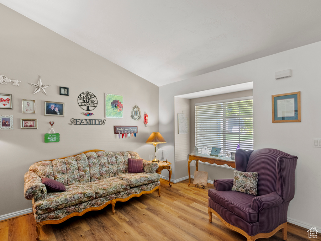 Living room featuring lofted ceiling and wood finished floors