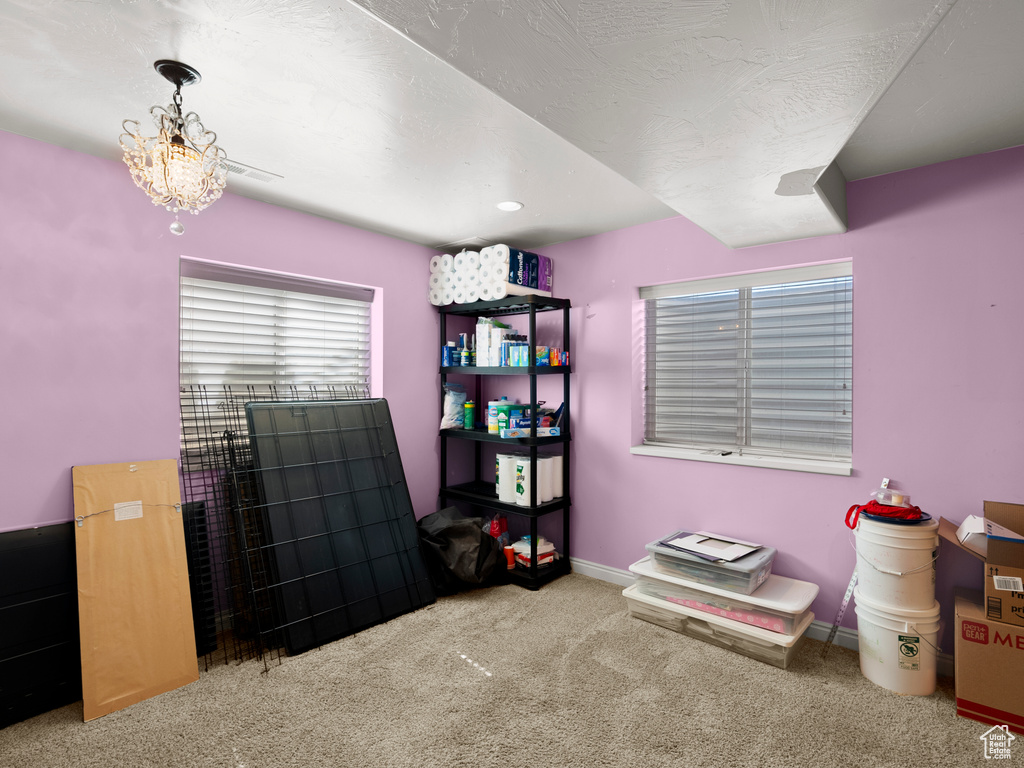 Misc room featuring carpet and a chandelier