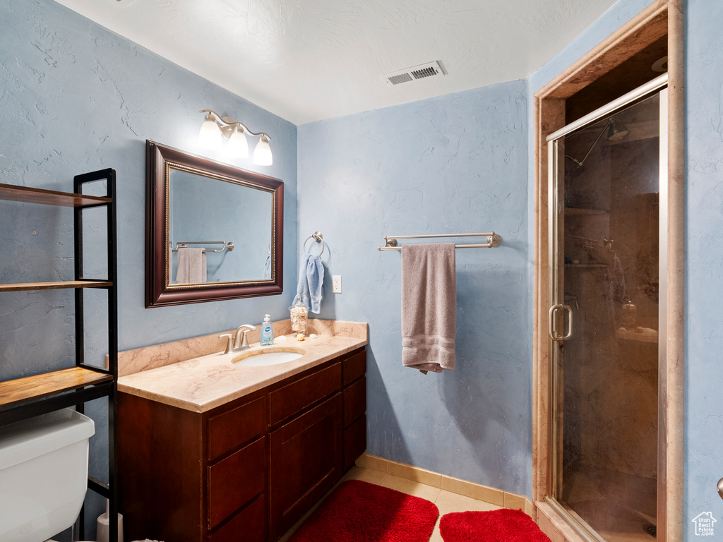 Full bathroom with vanity, a shower stall, and tile patterned flooring