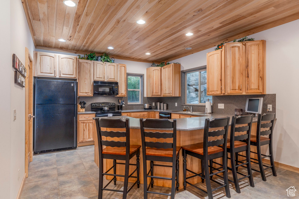 Kitchen with black appliances, recessed lighting, a peninsula, wood ceiling, and backsplash