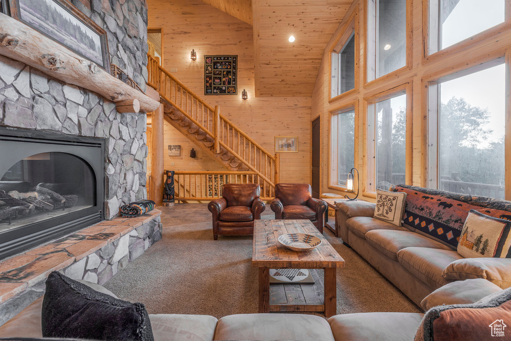 Living room with high vaulted ceiling, stairs, carpet, wooden ceiling, and a fireplace