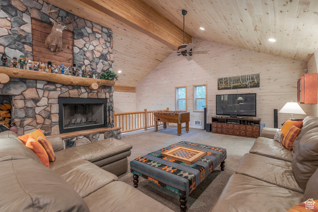 Living area with high vaulted ceiling, a wood ceiling with exposed beams, carpet floors, a fireplace, and recessed lighting