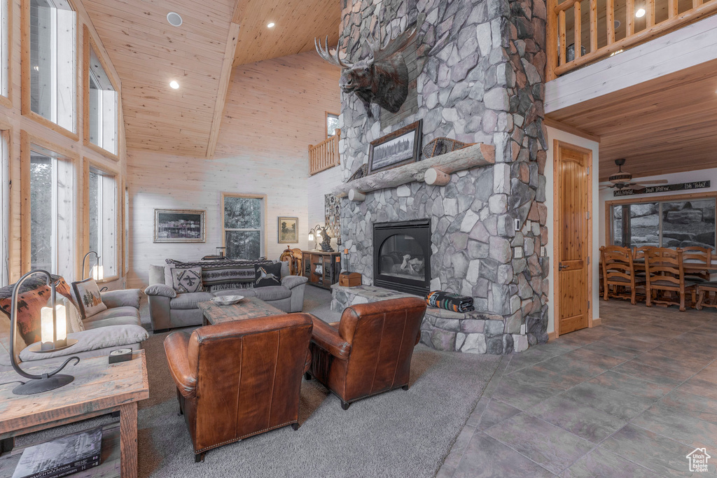 Living room featuring high vaulted ceiling, wood ceiling, a fireplace, and recessed lighting