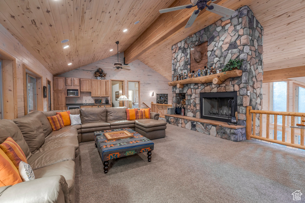 Living room featuring ceiling fan, carpet, recessed lighting, a wooden ceiling with exposed beams, and a fireplace