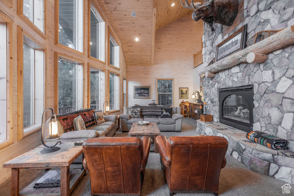 Carpeted living room with high vaulted ceiling, wood ceiling, a fireplace, and recessed lighting