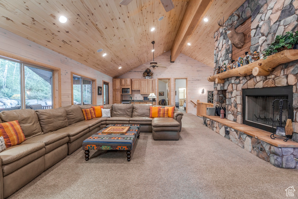 Carpeted living area with ceiling fan, high vaulted ceiling, recessed lighting, a fireplace, and a wood ceiling with exposed beams