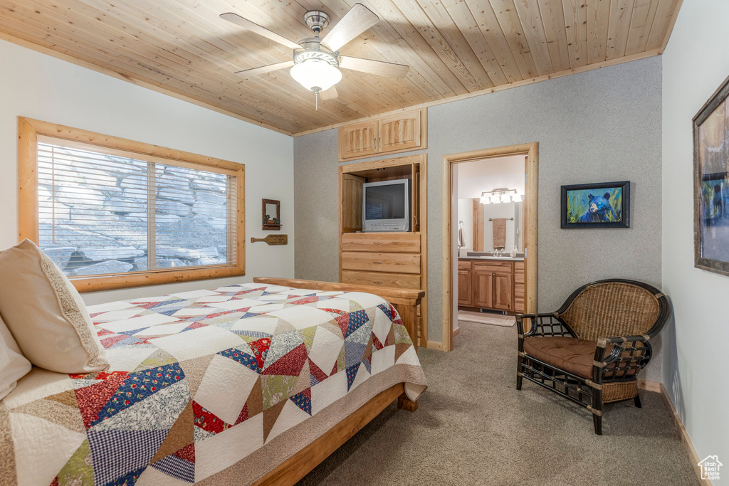 Bedroom with light carpet, wood ceiling, ensuite bathroom, and a ceiling fan