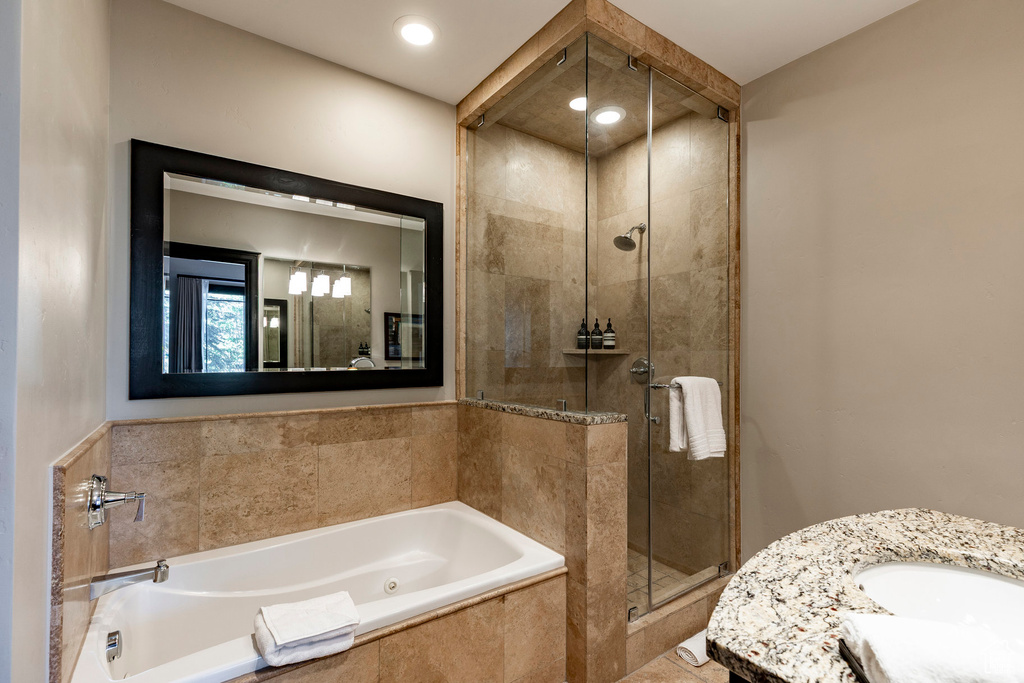 Bathroom with a shower stall, a whirlpool tub, and vanity