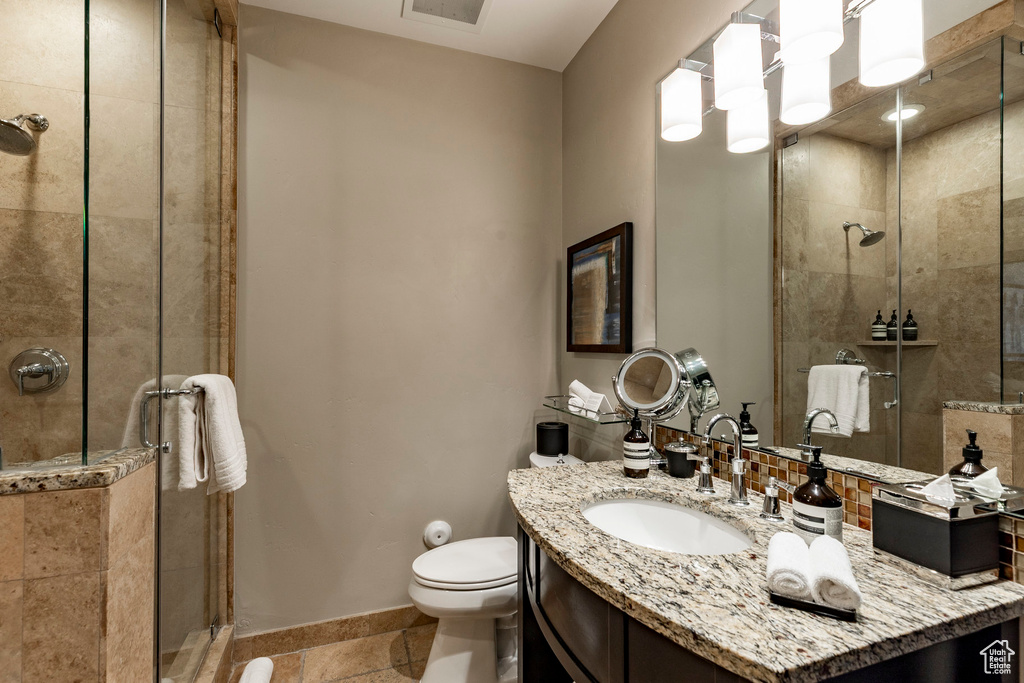 Full bathroom featuring a stall shower, vanity, and tile patterned floors