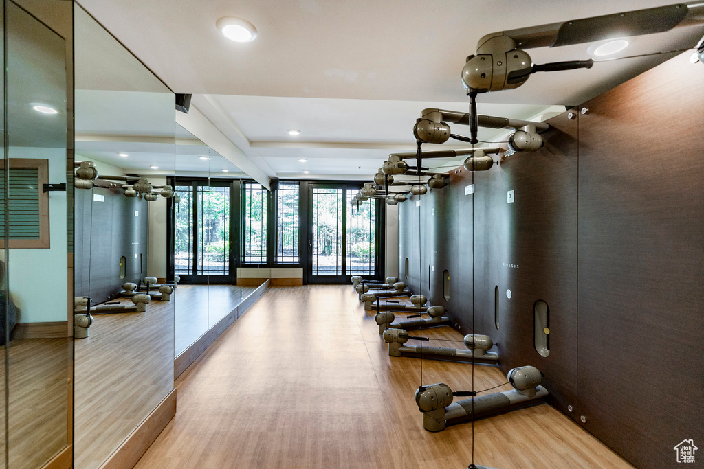 Exercise room featuring wood finished floors, recessed lighting, and a wall of windows