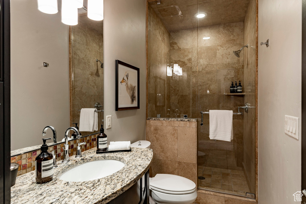 Bathroom with a stall shower, vanity, and recessed lighting