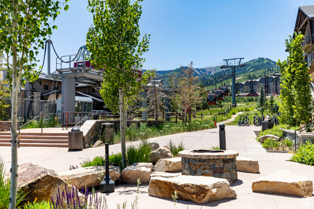 View of community with an outdoor fire pit, a mountain view, and a patio
