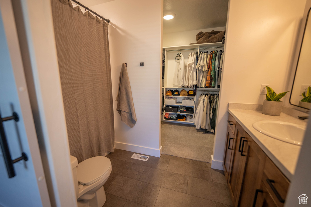 Full bath featuring vanity, a spacious closet, tile patterned floors, and a shower with curtain