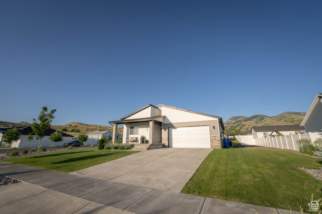 View of front of home with a mountain view, a garage, and concrete driveway