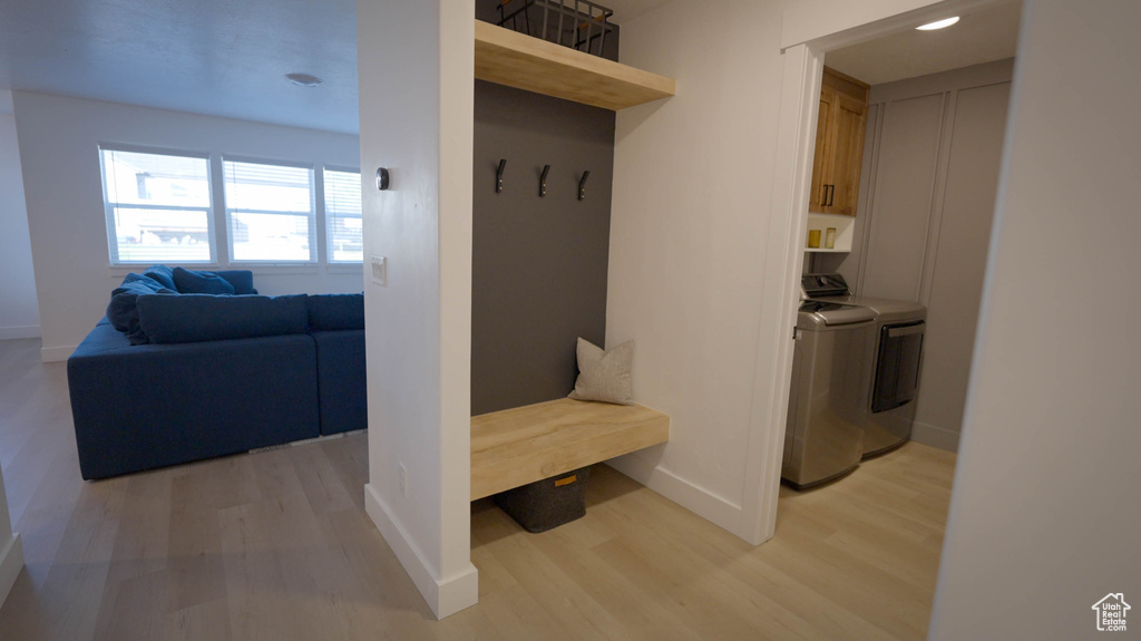 Mudroom with light wood-type flooring and washer and dryer