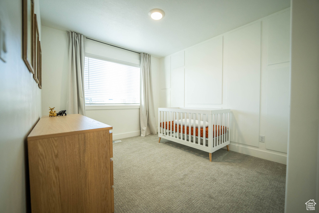 Bedroom featuring light carpet and baseboards