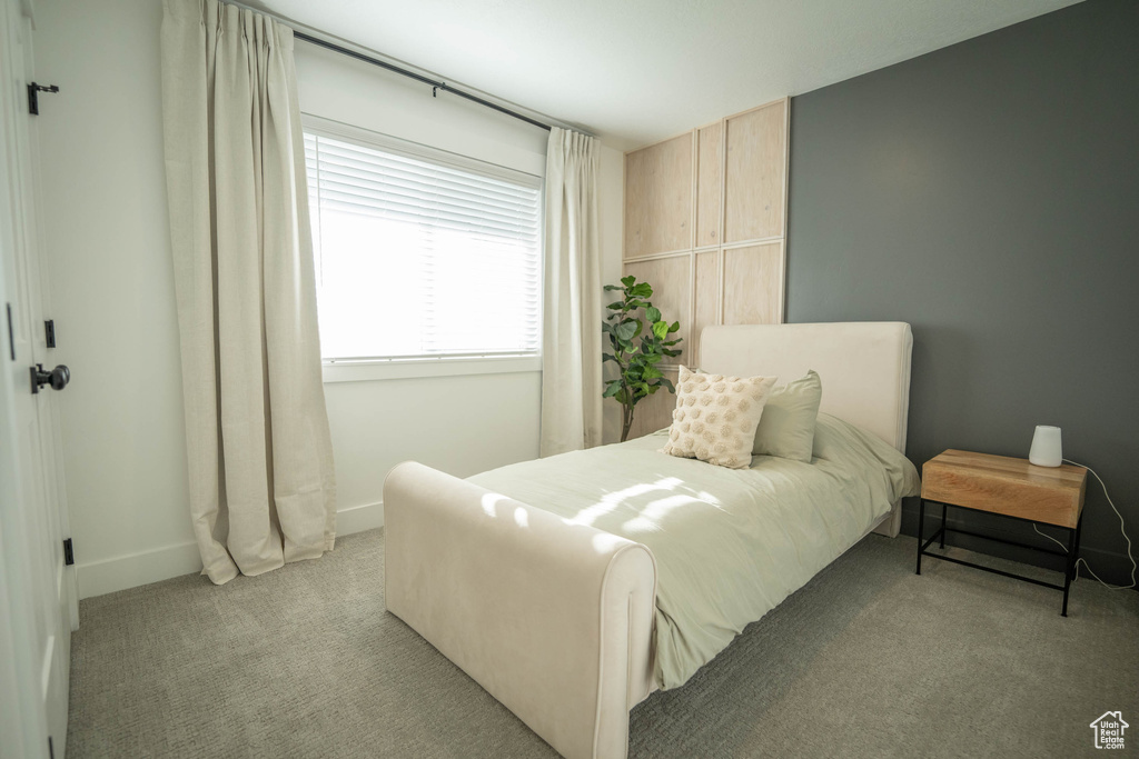 Bedroom with light colored carpet and baseboards