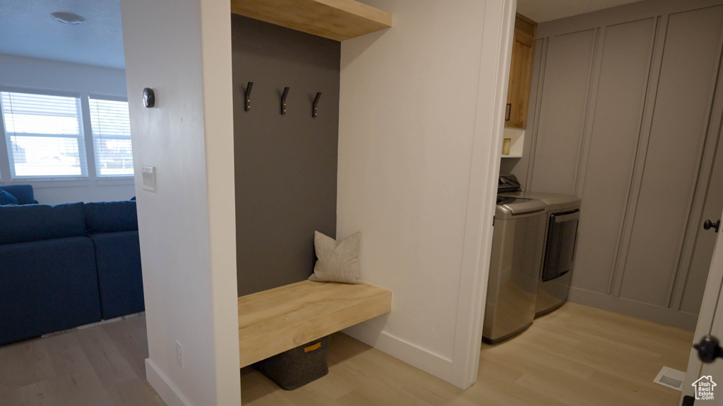 Mudroom featuring light wood-type flooring and independent washer and dryer