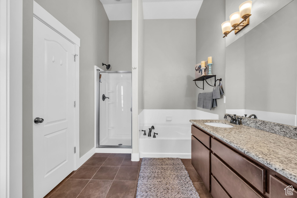Bathroom featuring a bath, a stall shower, vanity, and tile patterned floors