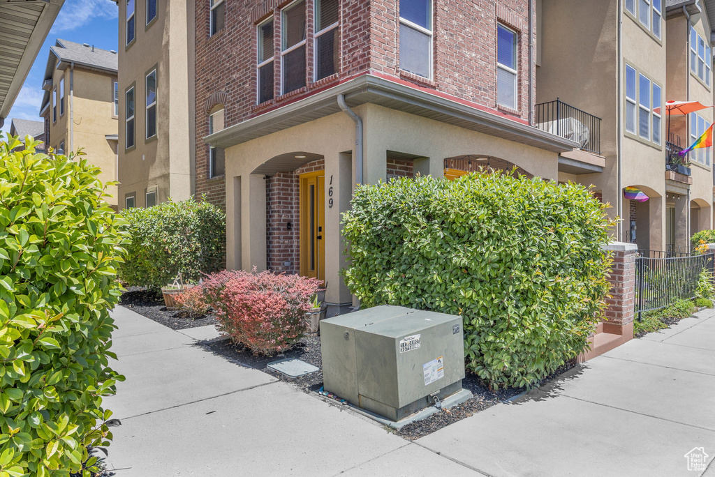 Doorway to property featuring brick siding and stucco siding