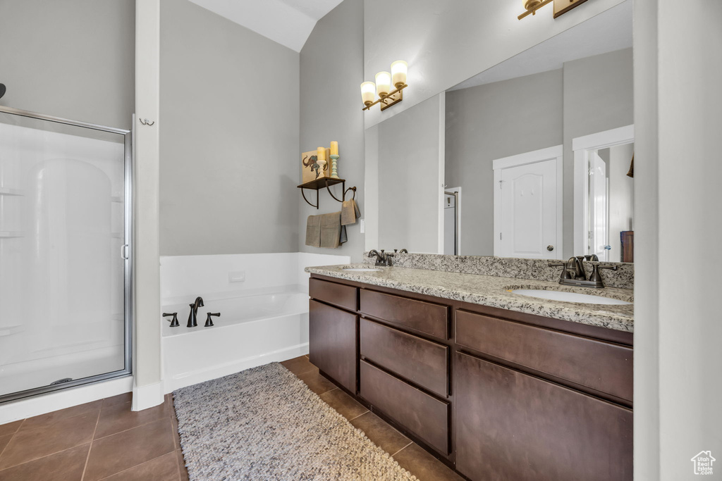Bathroom with a stall shower, tile patterned floors, a garden tub, and double vanity