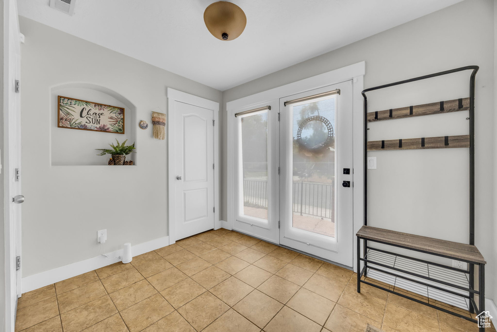 Entryway featuring light tile patterned floors and baseboards