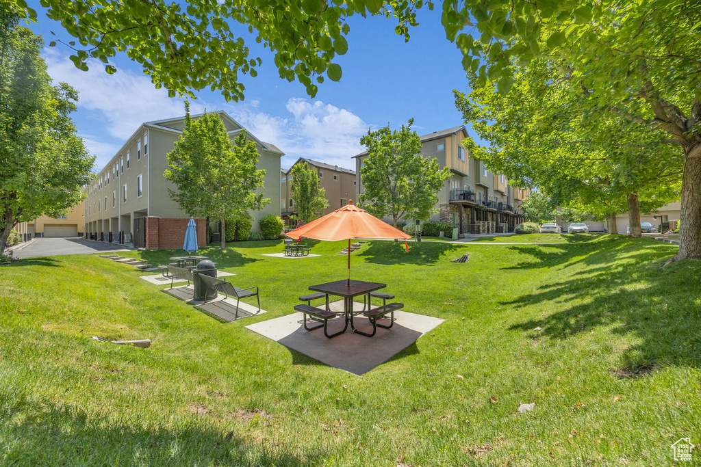 View of home's community with a yard, a patio area, and a residential view