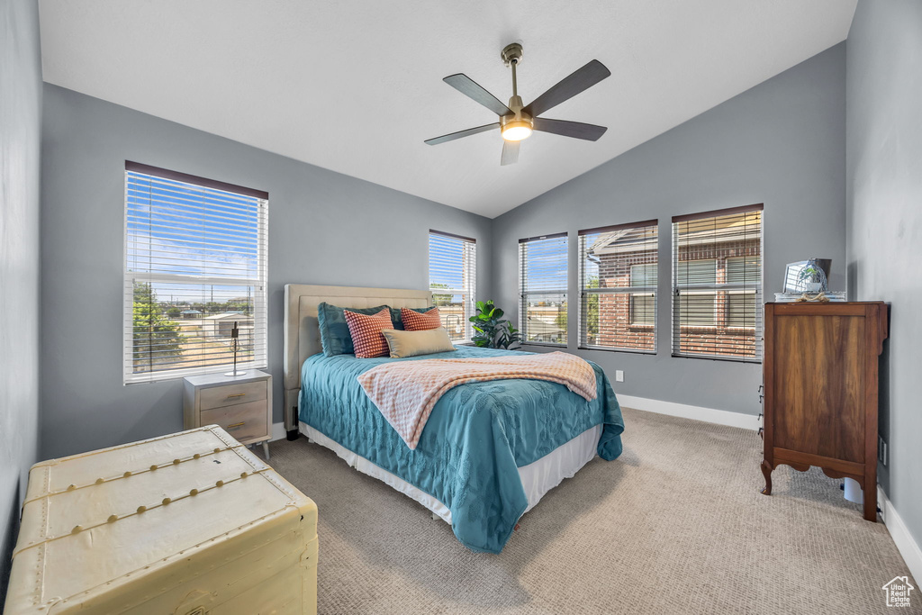 Carpeted bedroom with vaulted ceiling and ceiling fan