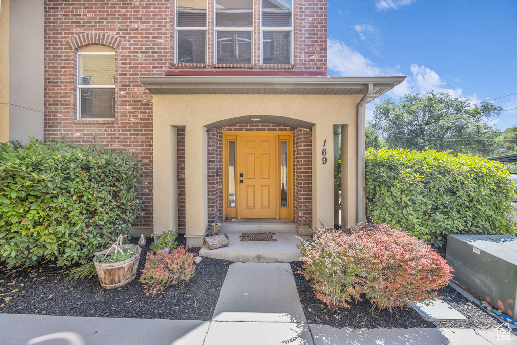 Entrance to property with stucco siding and brick siding