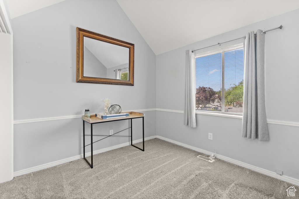 Carpeted office with vaulted ceiling and baseboards