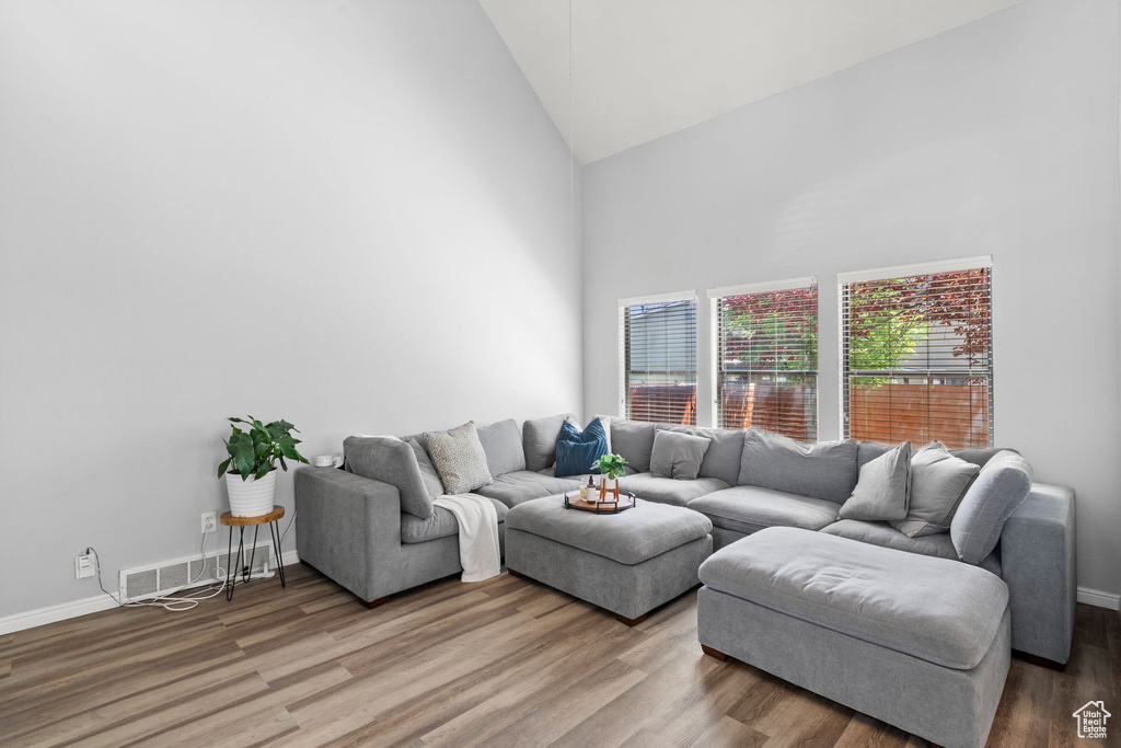 Living room with high vaulted ceiling and wood finished floors