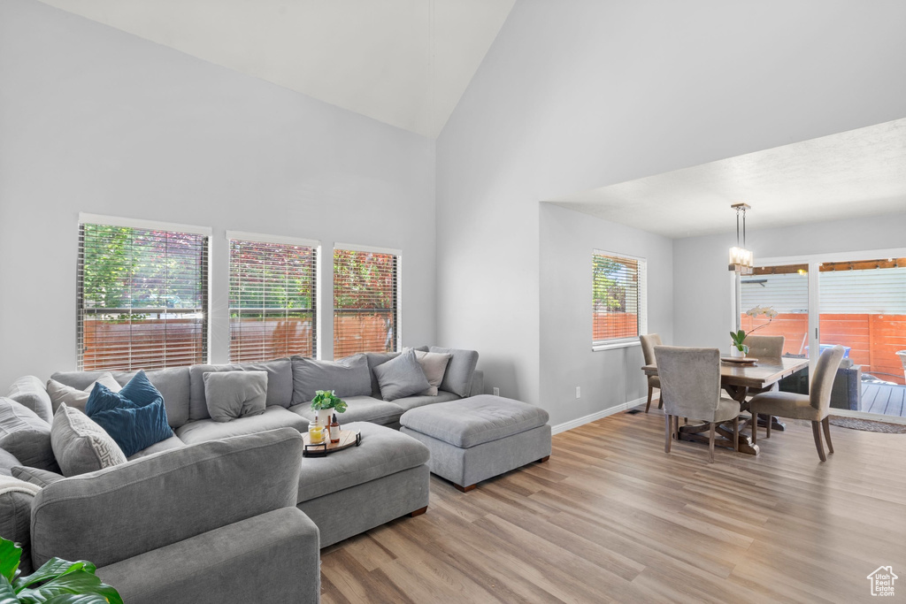 Living area with high vaulted ceiling and light wood-style floors