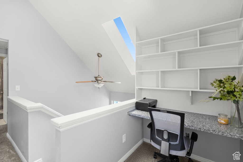 Unfurnished office with carpet, a ceiling fan, and built in desk