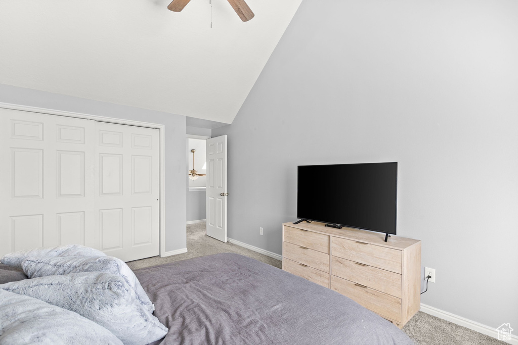 Bedroom featuring carpet, ceiling fan, lofted ceiling, and a closet